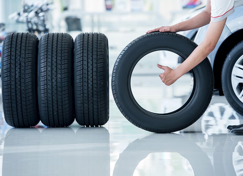Photo of a mechanic rolling a tire